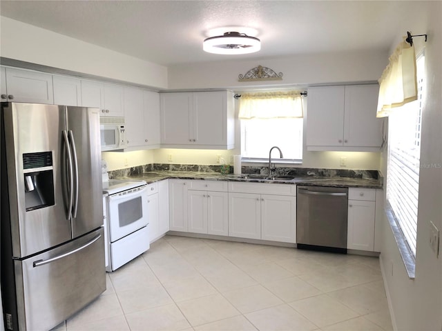 kitchen featuring a textured ceiling, stainless steel appliances, sink, white cabinets, and light tile patterned flooring