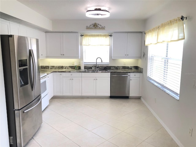 kitchen featuring white cabinets, sink, light tile patterned floors, and stainless steel appliances