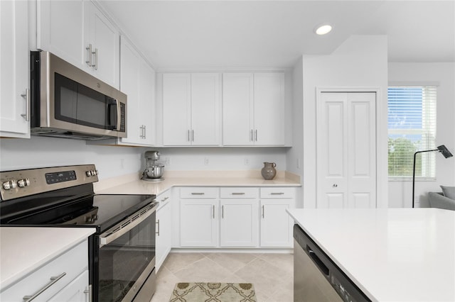 kitchen with white cabinets, light tile patterned floors, and stainless steel appliances