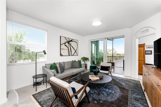 living room with a wealth of natural light and light tile patterned flooring