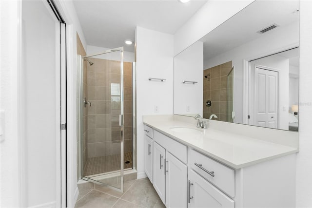 bathroom with tile patterned flooring, vanity, and a shower with door