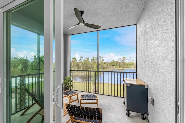 sunroom with a water view and ceiling fan