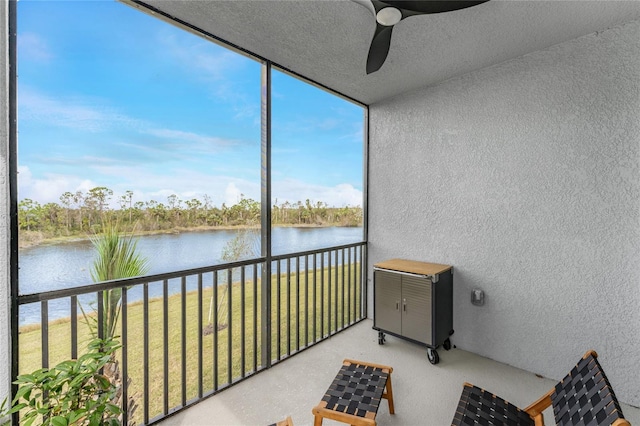 sunroom / solarium featuring a water view and ceiling fan