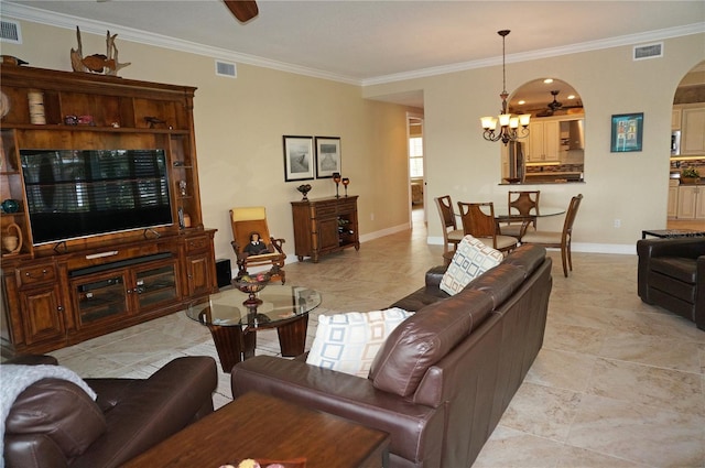 living room featuring a chandelier, arched walkways, crown molding, and baseboards