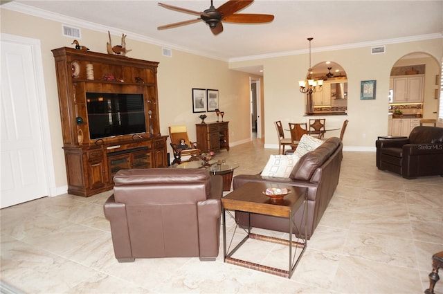 living room with a ceiling fan, arched walkways, a chandelier, ornamental molding, and baseboards