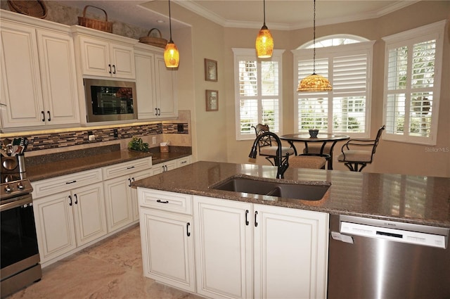 kitchen with crown molding, stainless steel appliances, pendant lighting, sink, and dark stone countertops