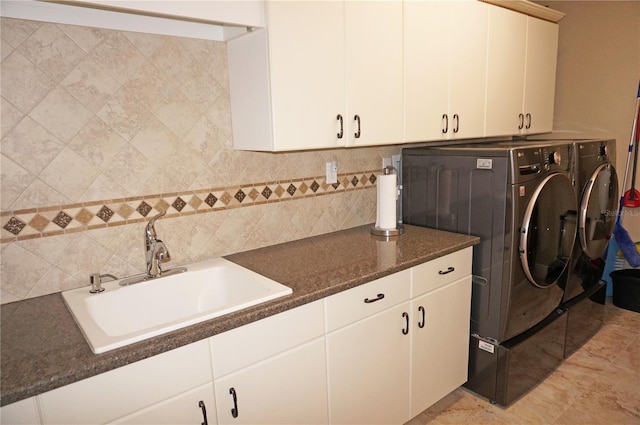 laundry area with cabinets, light tile patterned flooring, sink, washer and clothes dryer, and tile walls