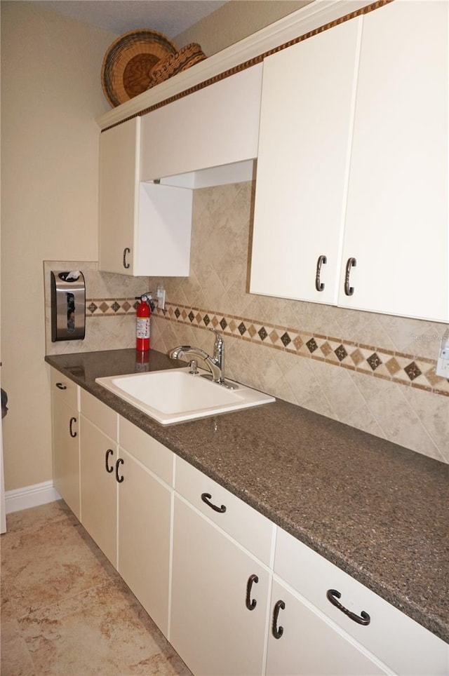 washroom with a sink and baseboards