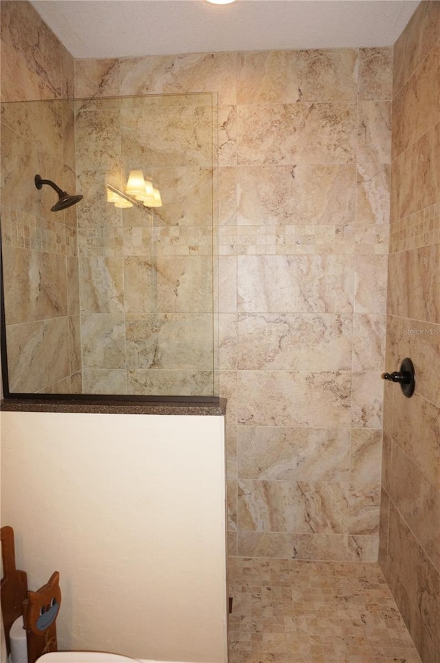 bathroom featuring toilet and tiled shower