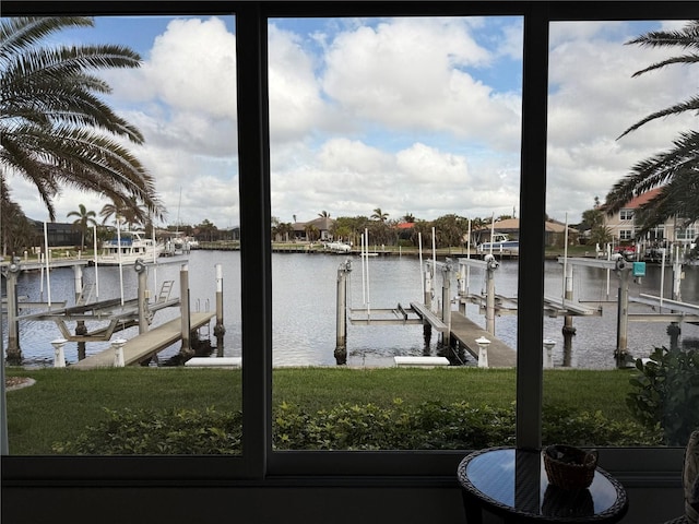 view of dock featuring a lawn and a water view