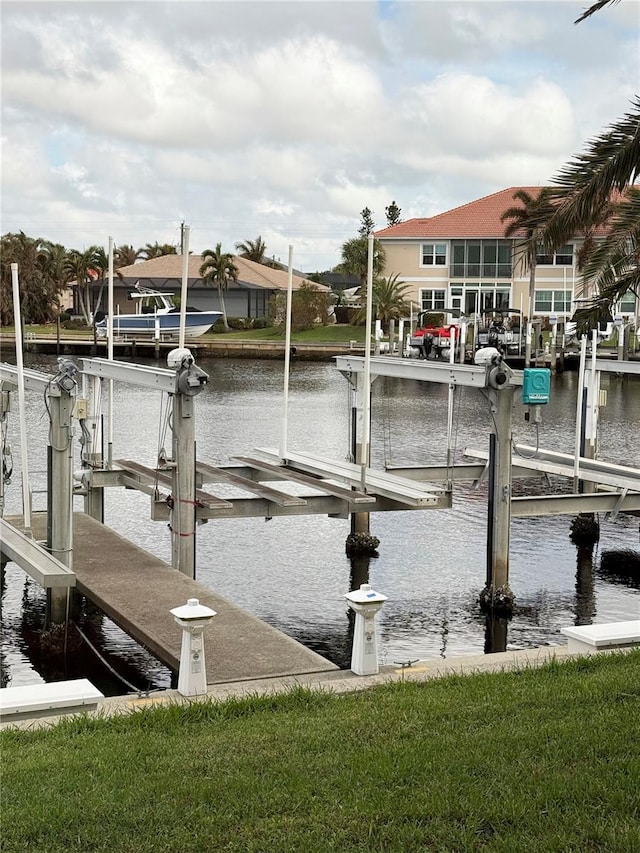 view of dock featuring a water view and a yard