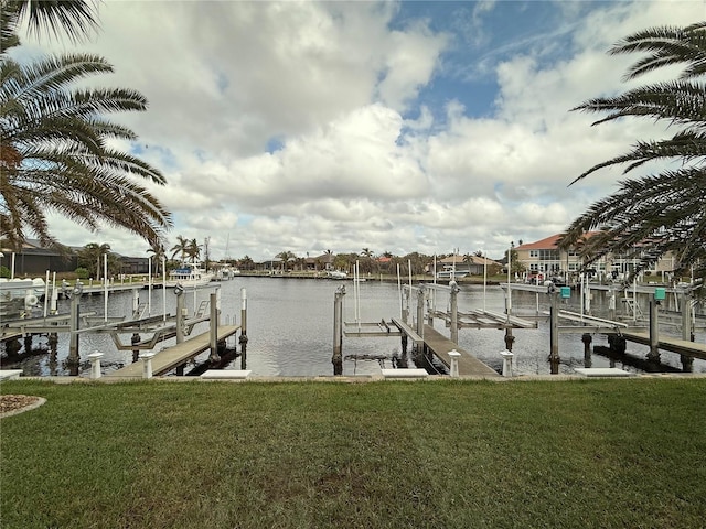 dock area featuring boat lift, a water view, and a yard