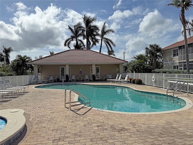 community pool featuring fence and a patio