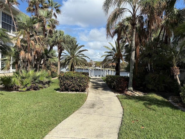 view of property's community with a water view and a yard