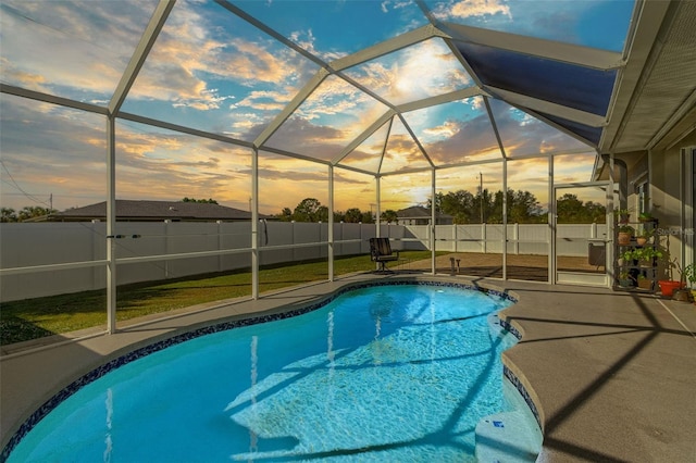 pool at dusk featuring a lanai and a patio