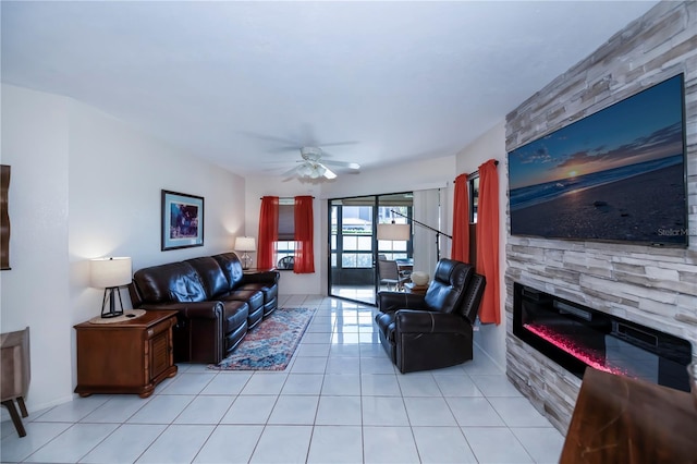 tiled living room featuring a fireplace and ceiling fan