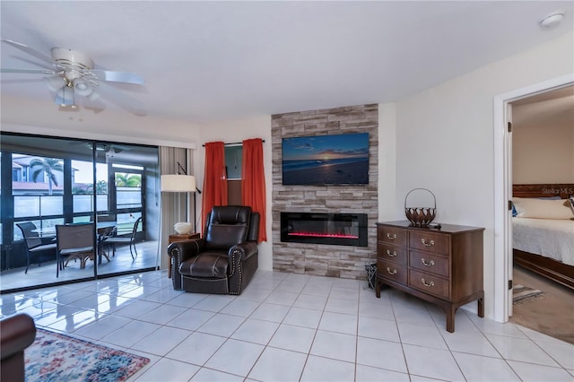 living room featuring ceiling fan, light tile patterned flooring, and a fireplace