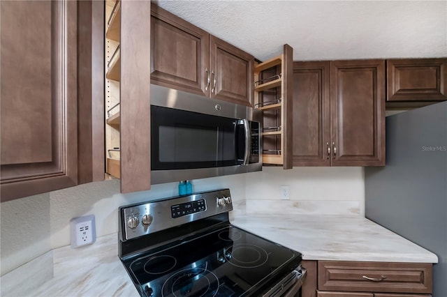 kitchen with dark brown cabinets, a textured ceiling, and black range with electric cooktop