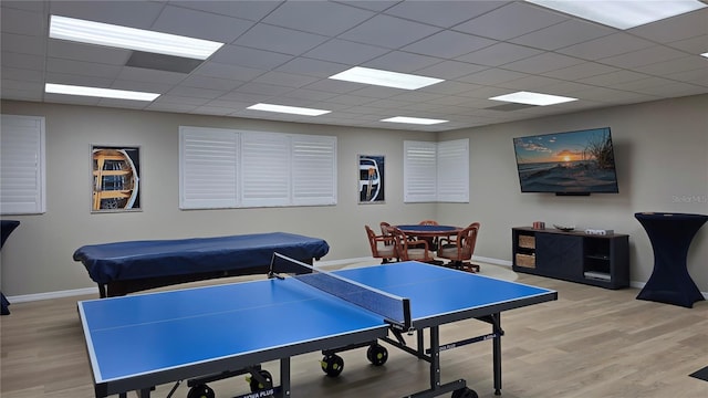 game room with a drop ceiling and light hardwood / wood-style floors