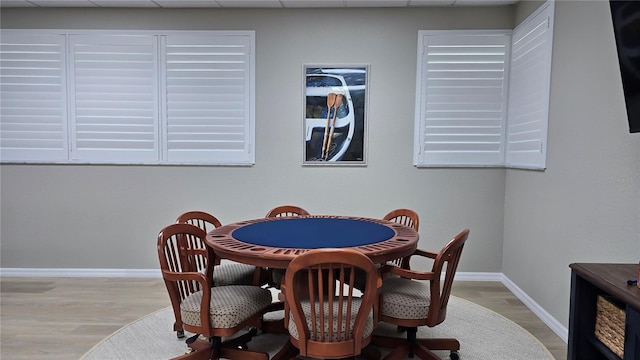 rec room with a drop ceiling and light hardwood / wood-style floors