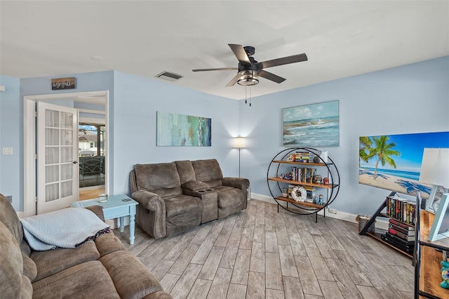 living room with light hardwood / wood-style flooring and ceiling fan