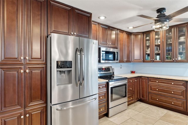 kitchen featuring stainless steel appliances, light tile patterned flooring, and ceiling fan