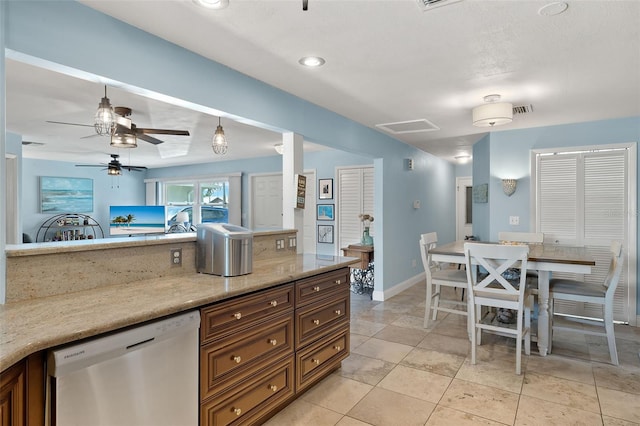 kitchen featuring light stone counters, light tile patterned floors, pendant lighting, stainless steel dishwasher, and ceiling fan