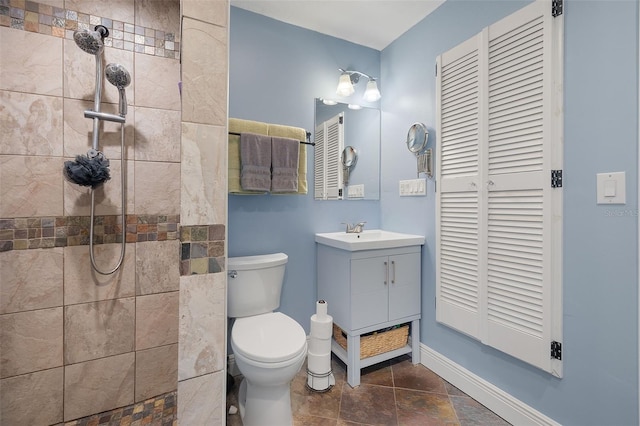 bathroom with toilet, vanity, and tiled shower