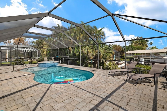 view of pool featuring a lanai, an in ground hot tub, and a patio area