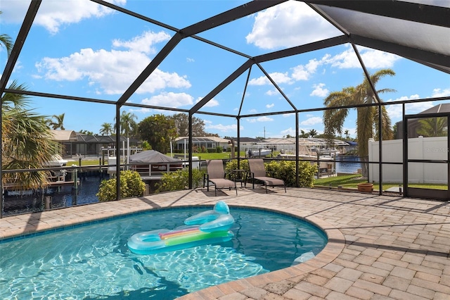 view of pool featuring a lanai, a water view, and a patio area