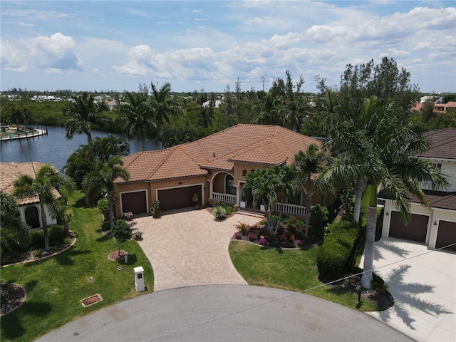 mediterranean / spanish-style house with a water view, covered porch, a front yard, and a garage