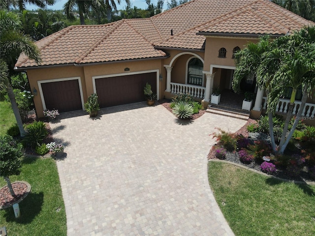 3507 Terin Ct, Punta Gorda, FL 33950 - mediterranean / spanish house with a porch, an attached garage, stucco siding, a tiled roof, and decorative driveway