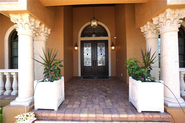 view of exterior entry featuring covered porch and french doors