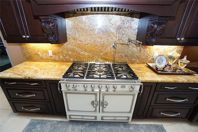 3507 Terin Ct, Punta Gorda, FL 33950 - kitchen featuring range with two ovens, light tile patterned flooring, tasteful backsplash, dark brown cabinetry, and light stone counters