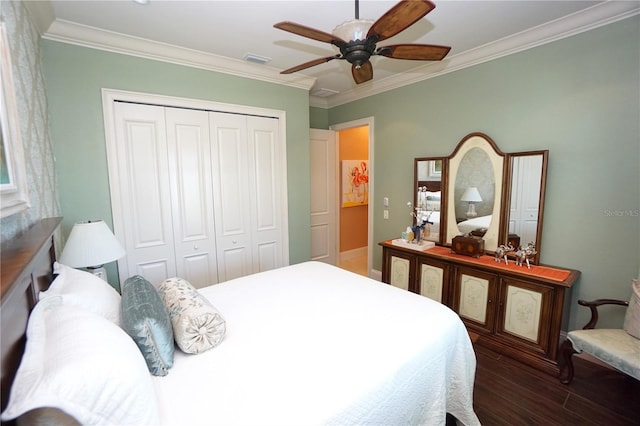 bedroom featuring ceiling fan, dark wood-type flooring, crown molding, and a closet