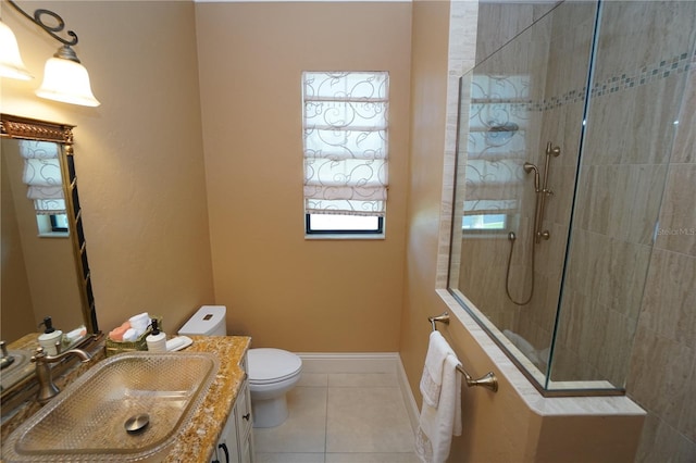 bathroom with toilet, a tile shower, vanity, and tile patterned floors