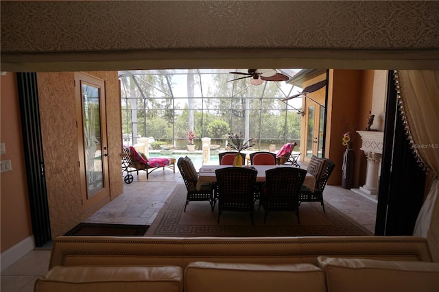 dining area with tile patterned floors, ceiling fan, and a high end fireplace