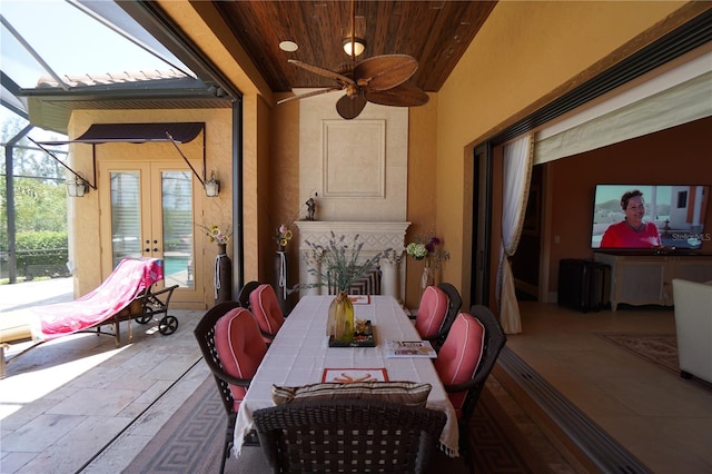 view of patio / terrace featuring ceiling fan, glass enclosure, and french doors