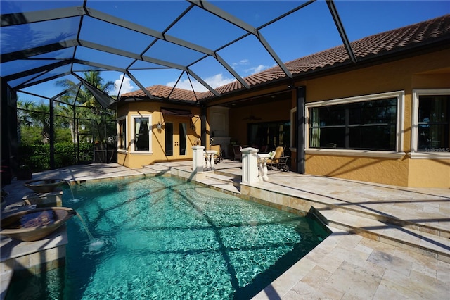 view of swimming pool with a lanai, pool water feature, french doors, and a patio