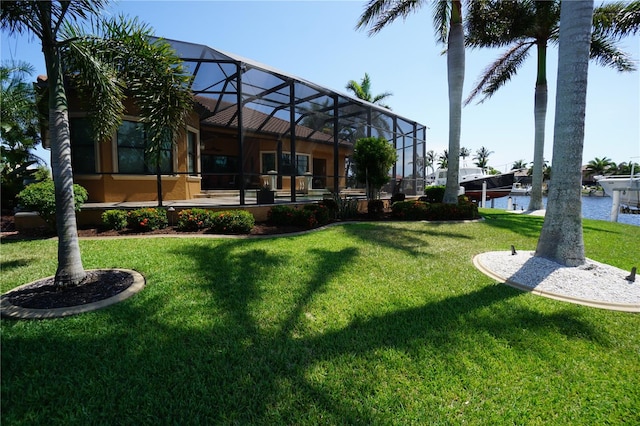 view of yard with glass enclosure and a water view