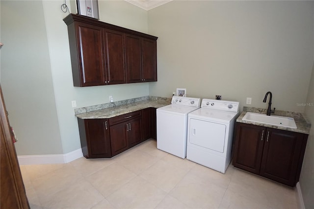 laundry area featuring cabinets, ornamental molding, sink, light tile patterned floors, and washing machine and clothes dryer