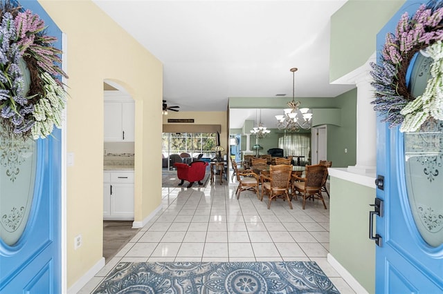 tiled entrance foyer featuring ceiling fan with notable chandelier