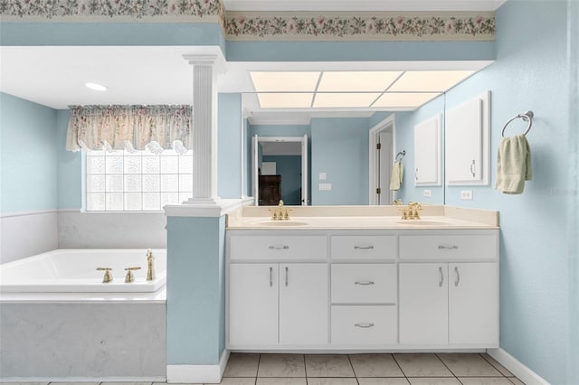 bathroom with decorative columns, a bathing tub, tile patterned floors, and vanity