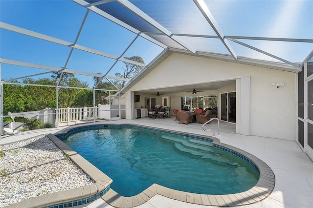 view of swimming pool with ceiling fan, a patio area, and glass enclosure