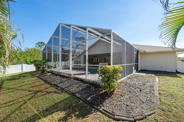 back of house featuring a lanai and a lawn