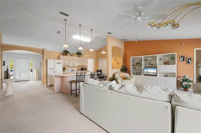 living room featuring high vaulted ceiling, light colored carpet, and ceiling fan