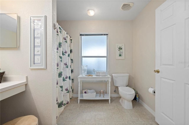 bathroom featuring toilet and a shower with curtain