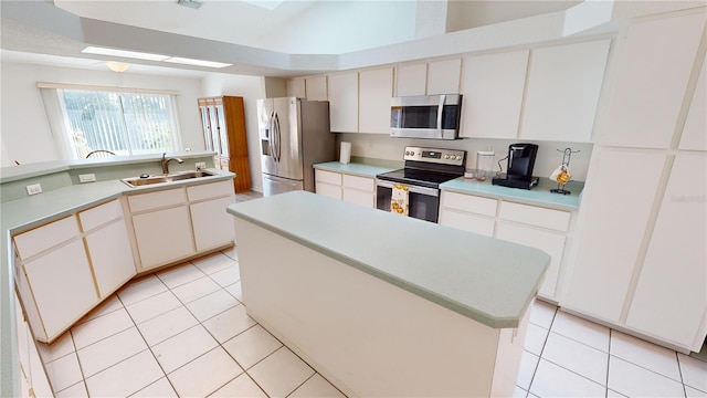 kitchen with a center island, sink, white cabinetry, and stainless steel appliances