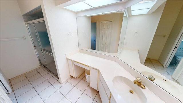 bathroom with tile patterned floors, vanity, toilet, and walk in shower