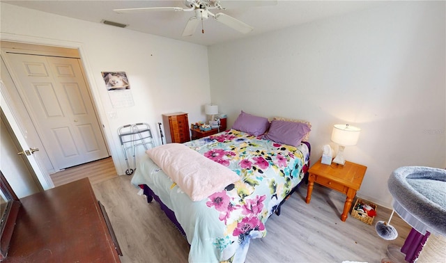 bedroom featuring a closet, light hardwood / wood-style flooring, and ceiling fan